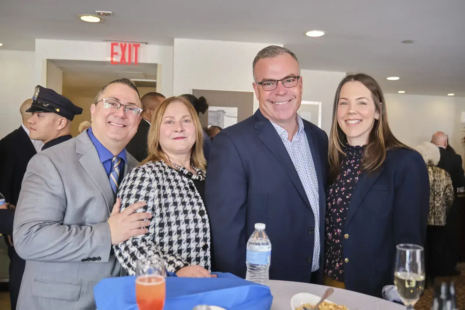 Four people posing together at school event reception