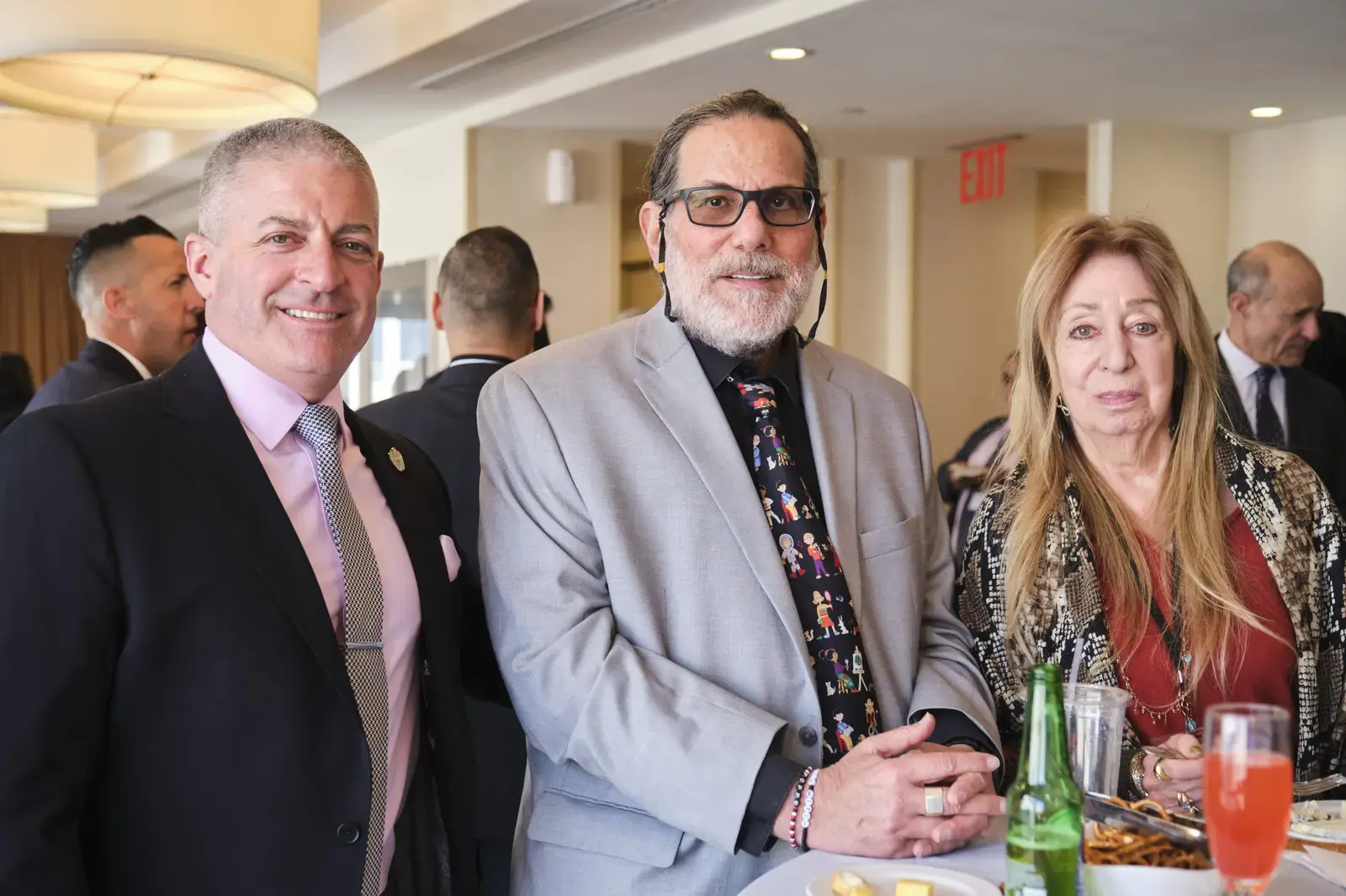 Three attendees smiling at formal school event reception