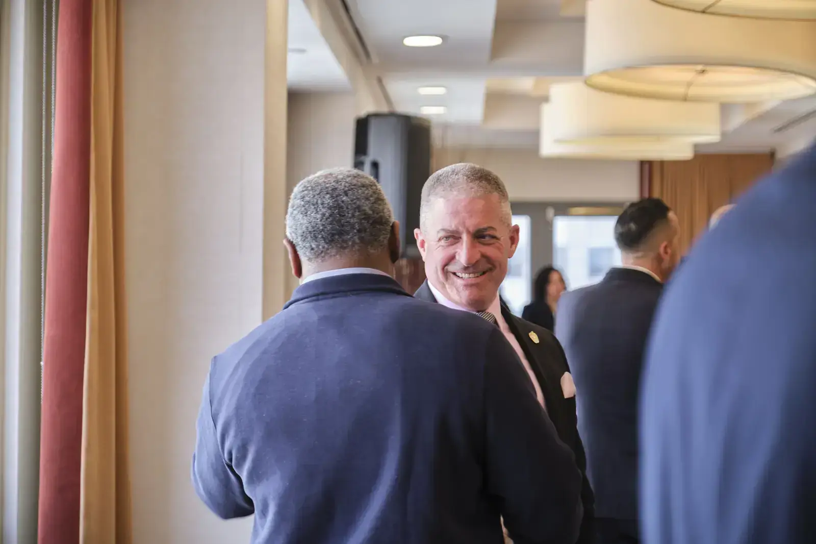 School administrator smiling while networking with colleagues at event