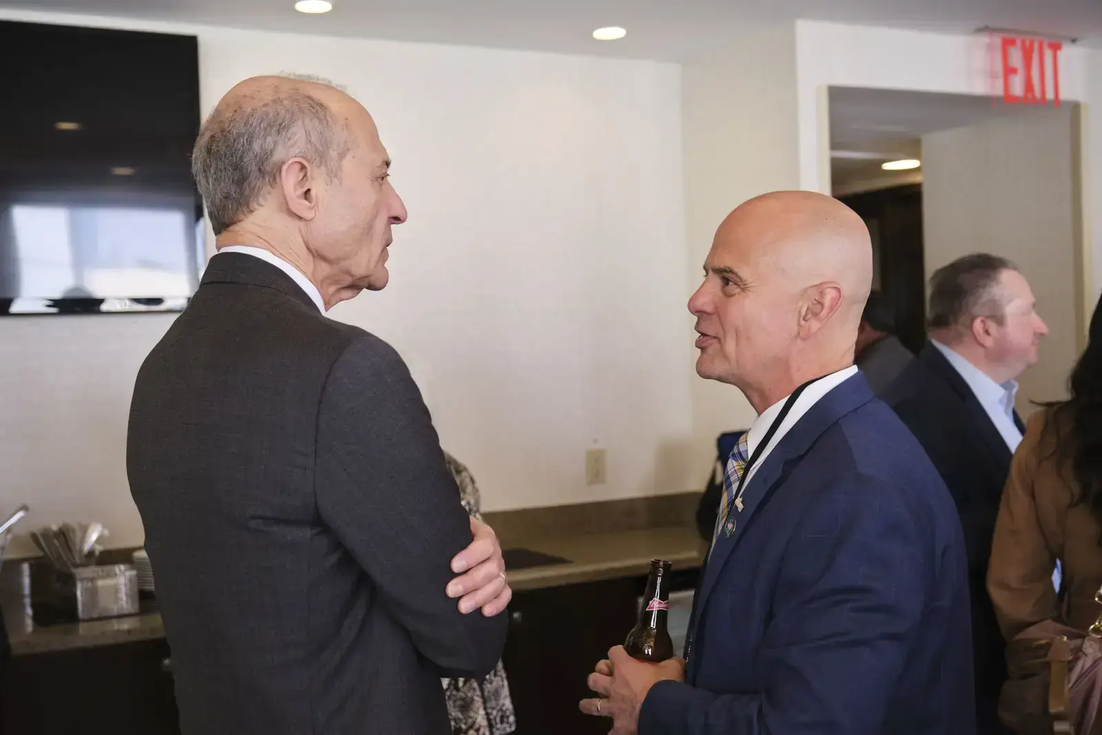 Two men in suits conversing at school event