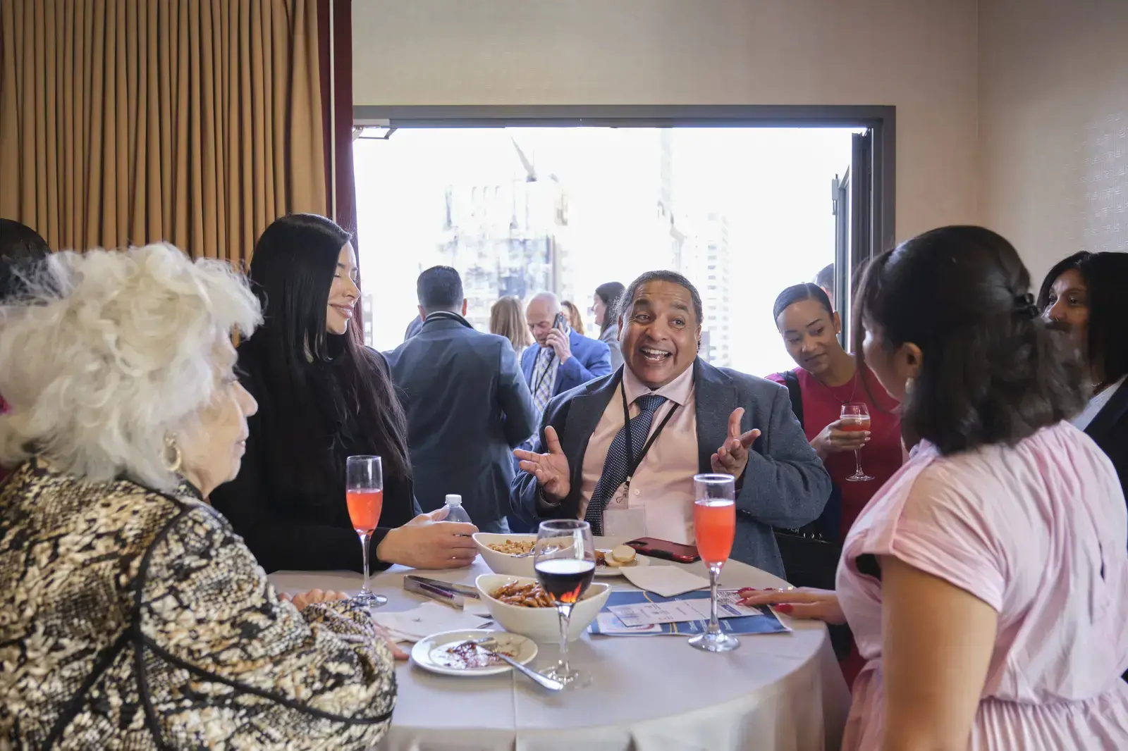 Guests socializing at a school reception event with food and drinks