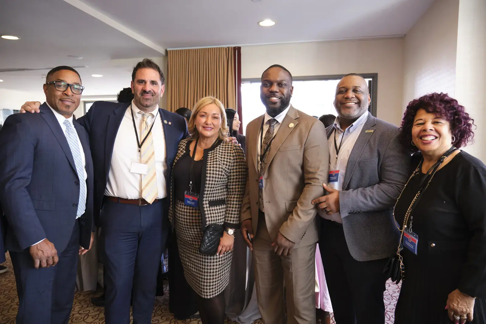 Six professionals posing together at a school conference event