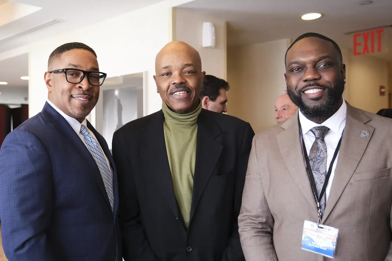 Three school administrators pose together at professional event