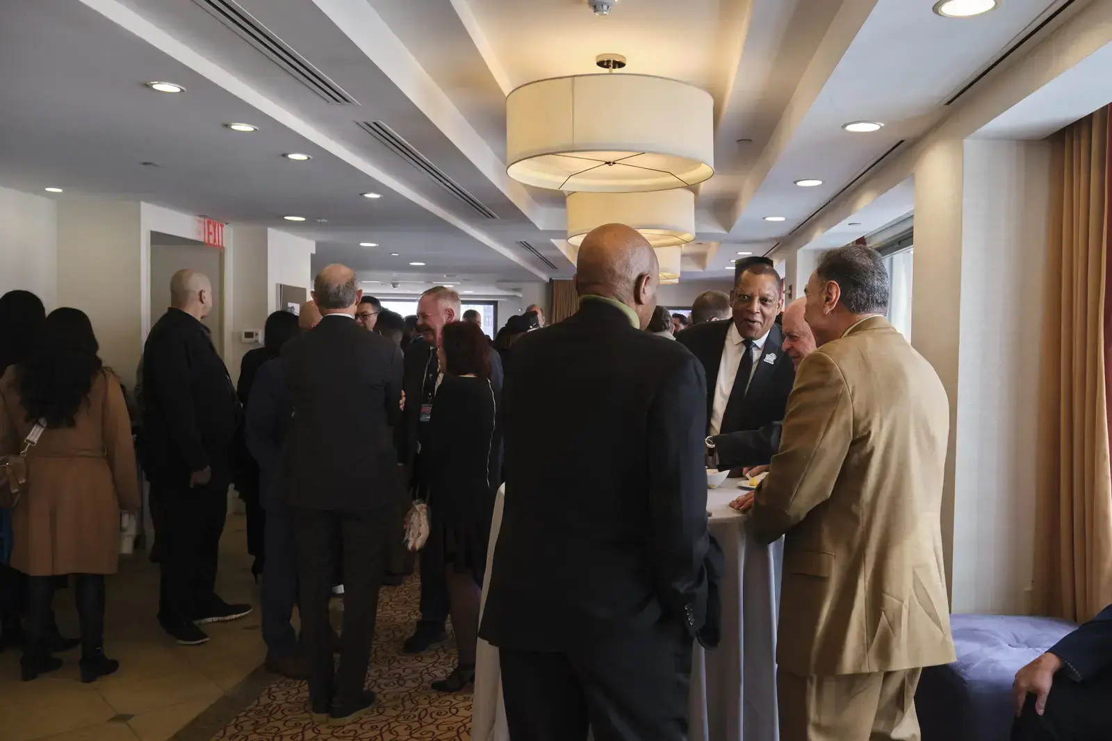 Attendees networking at formal reception in modern venue