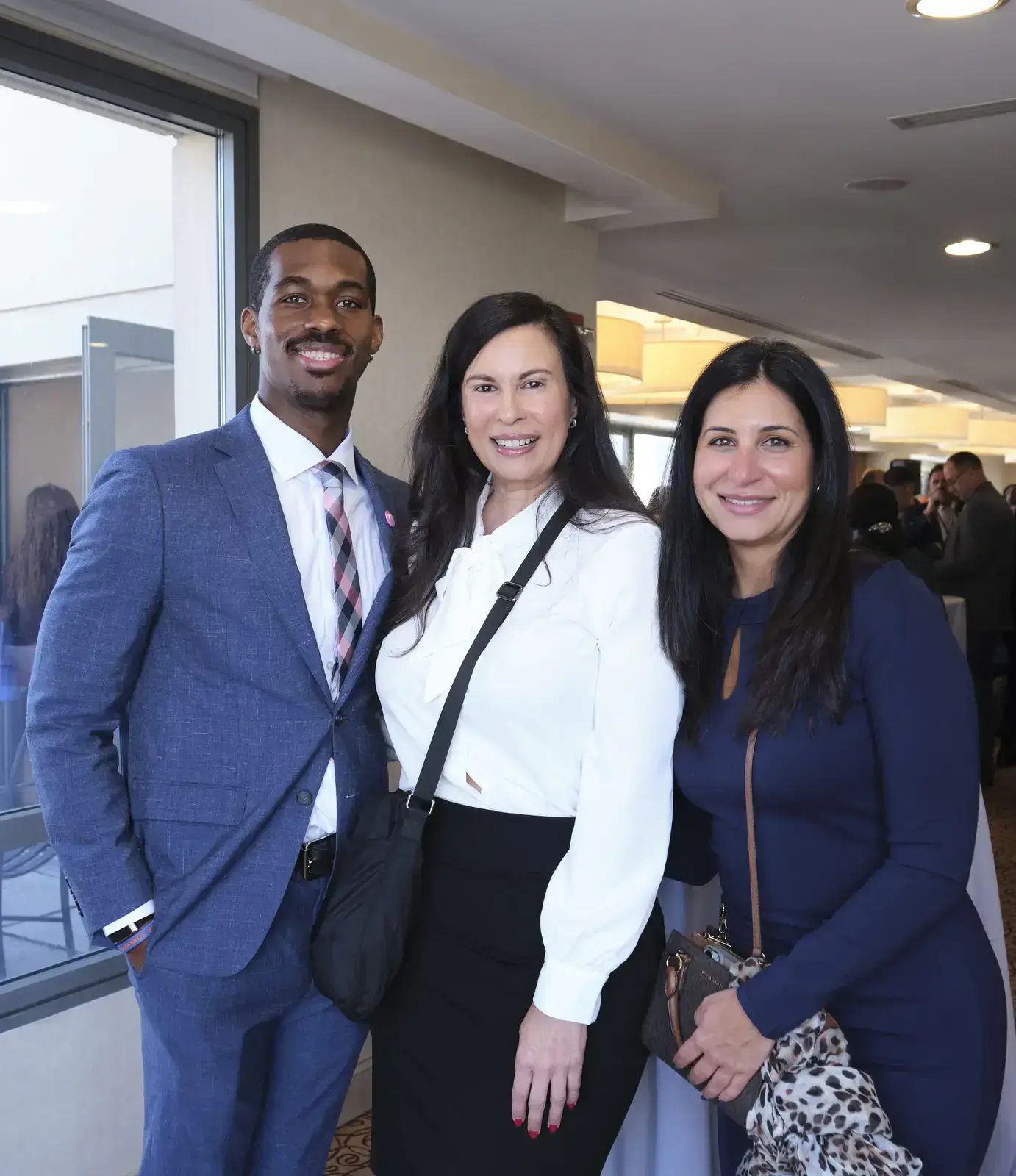 Three professionals smiling at school event