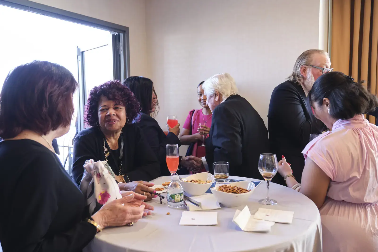 Faculty and staff gathering at reception with refreshments