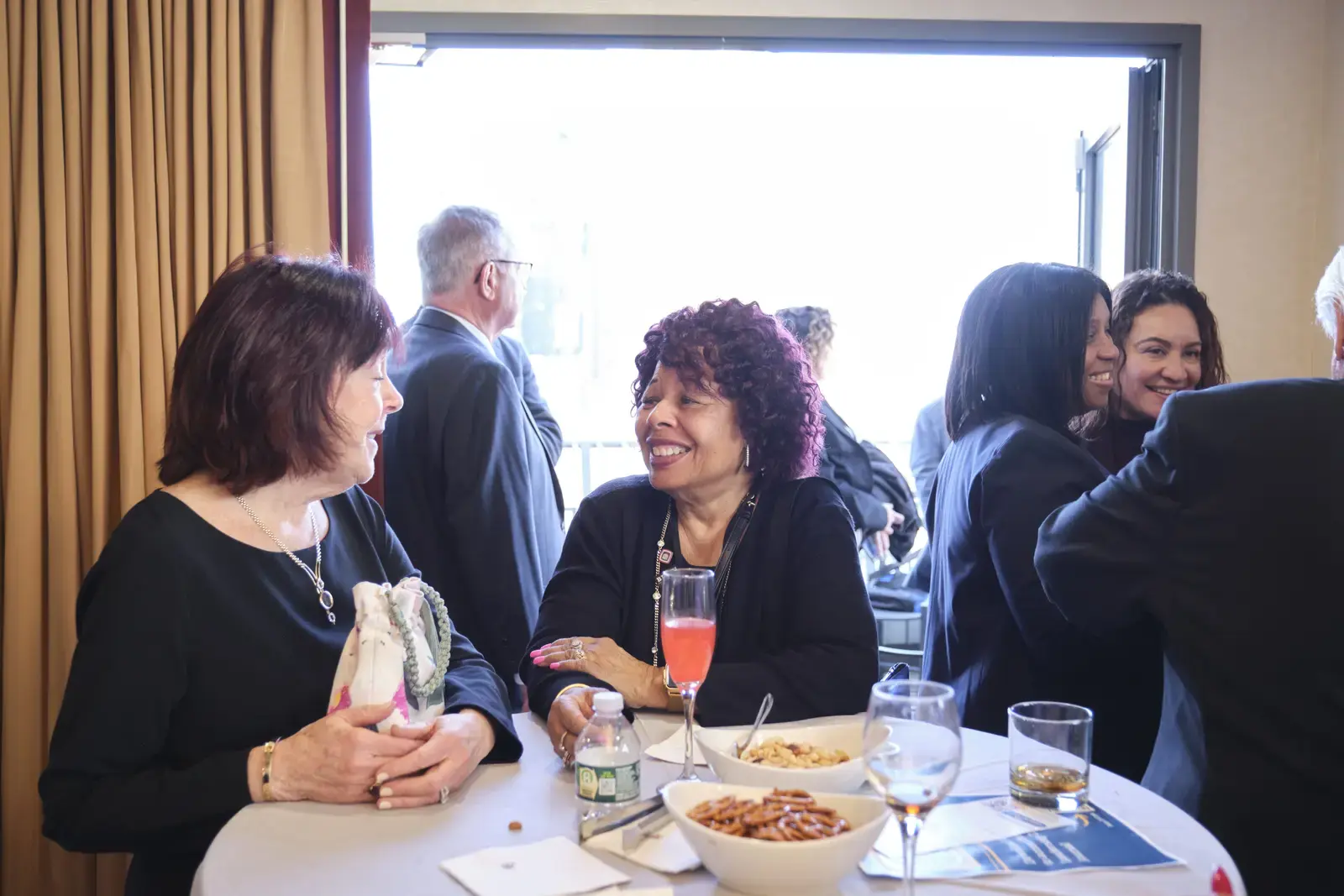 Attendees conversing at networking event reception table