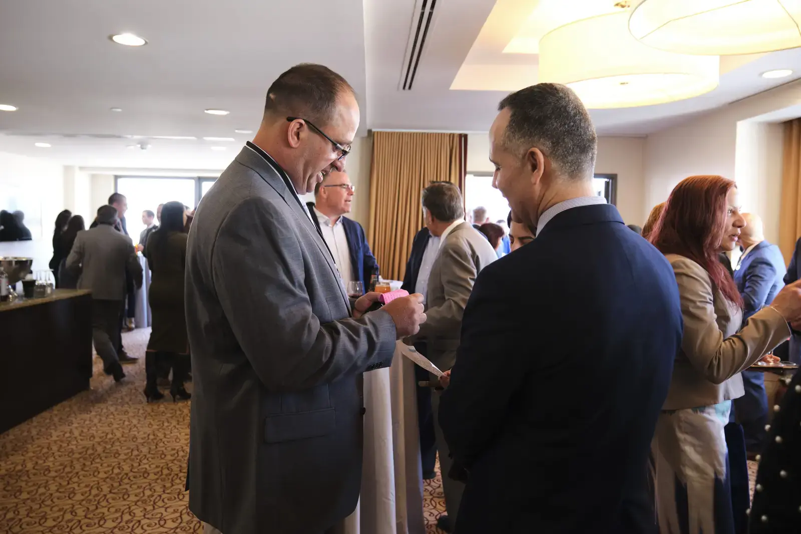 Professional networking event with attendees in business attire conversing