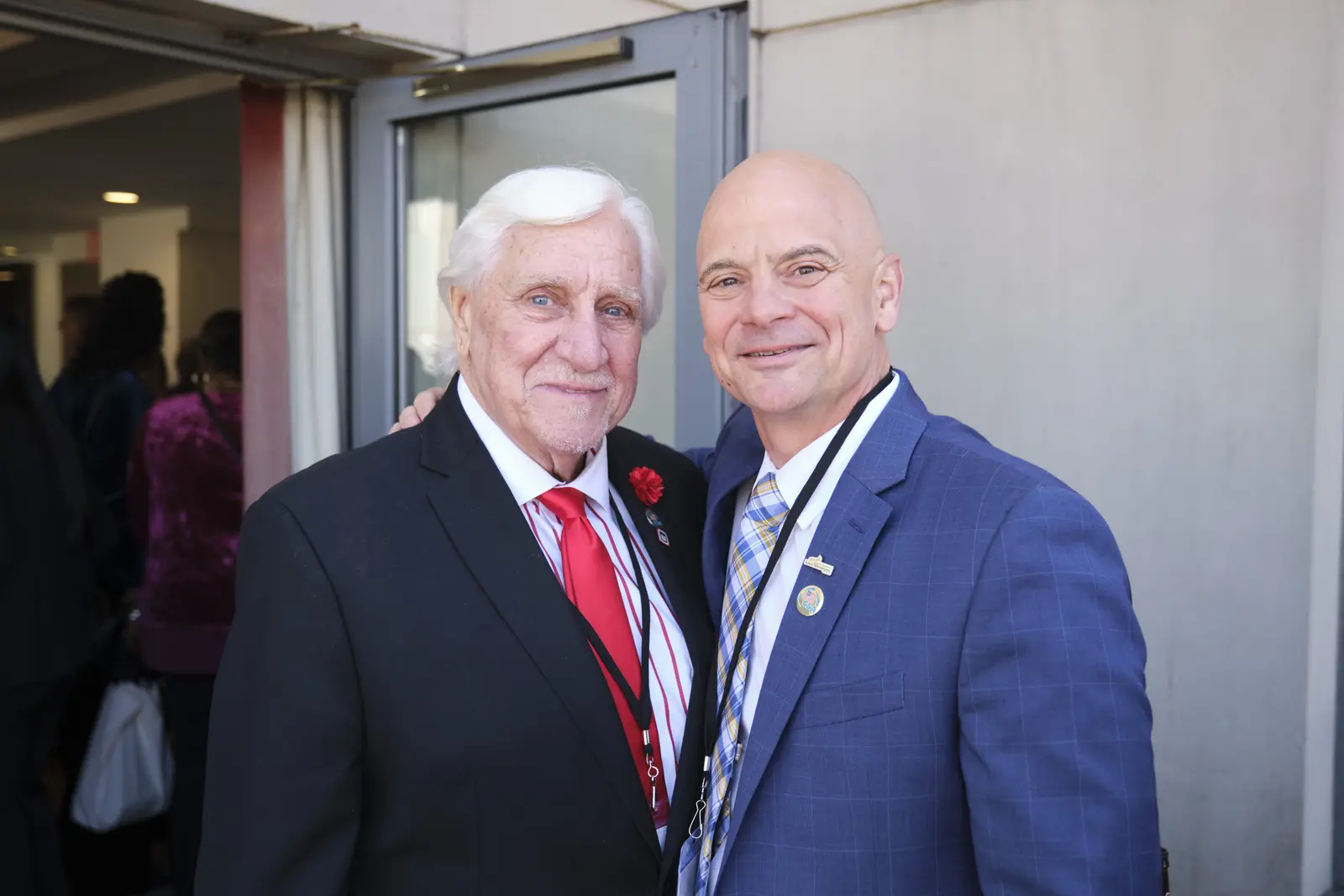 Two men in suits posing together at school event