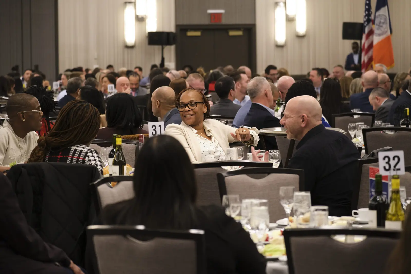 Attendees networking at formal banquet hall event with numbered tables