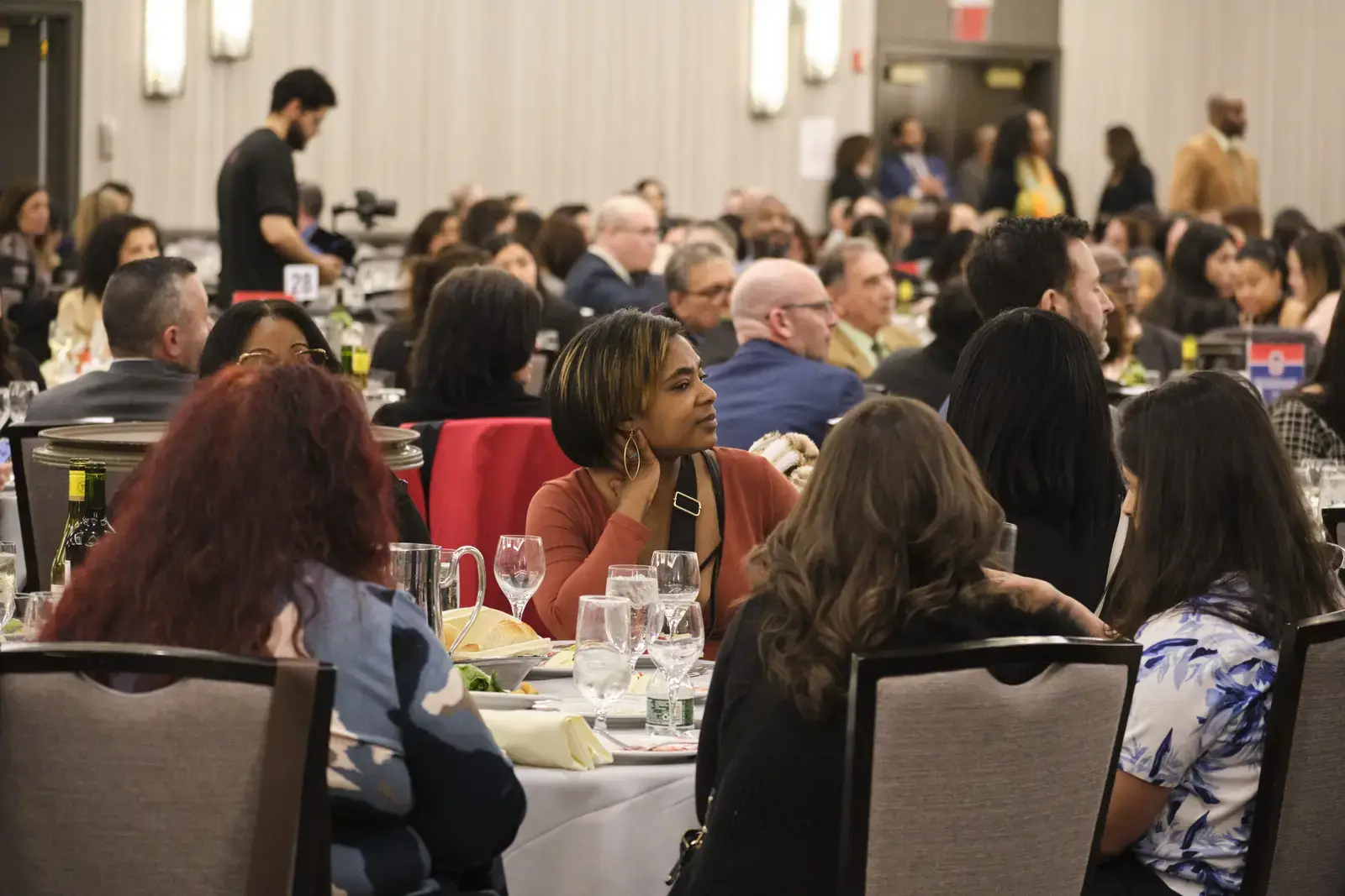 Attendees engaged in conversation at formal school luncheon event