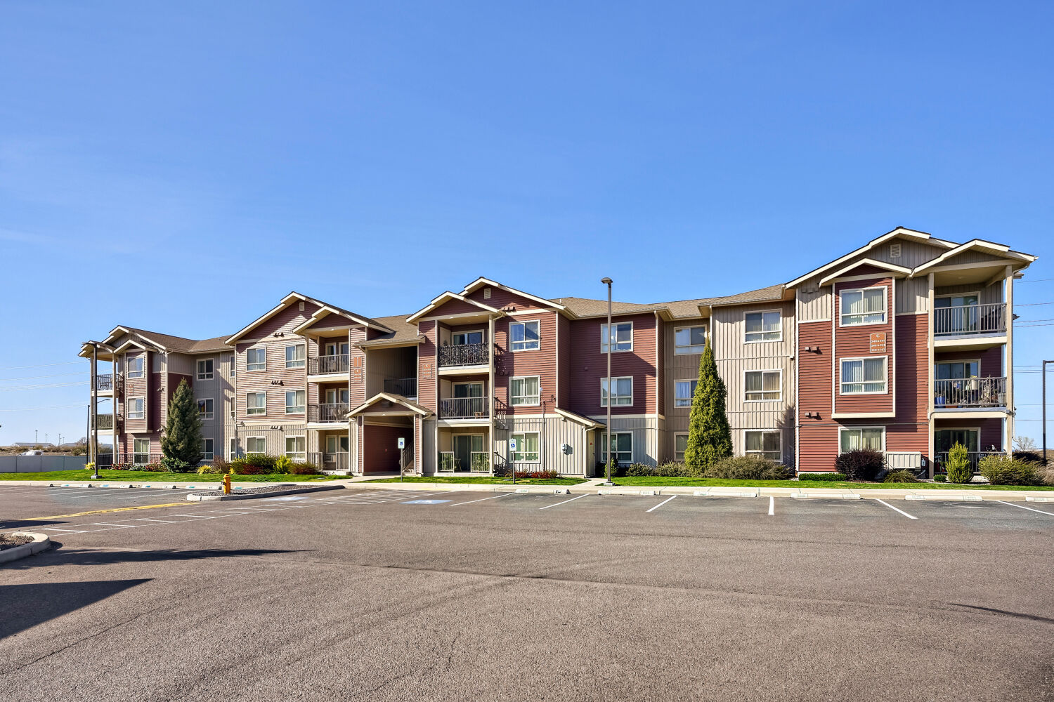 Exterior view of Copper Hill Apartments featuring modern apartment homes with private balconies and landscaped grounds in Spokane, Washington