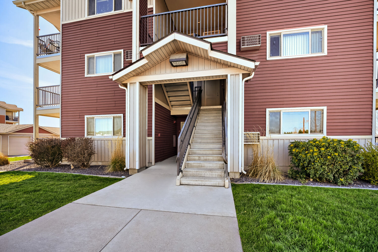 Welcoming entrance to a residential building at Copper Hill Apartments with landscaped walkways in Spokane, Washington