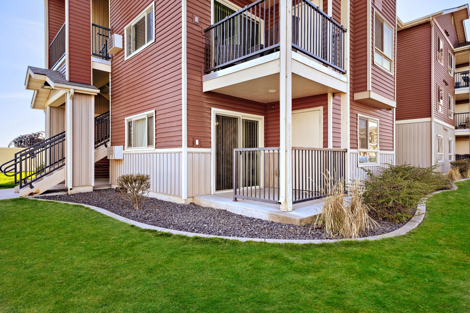 Ground-floor apartment home at Copper Hill Apartments featuring a private patio and landscaped outdoor space in Spokane, Washington