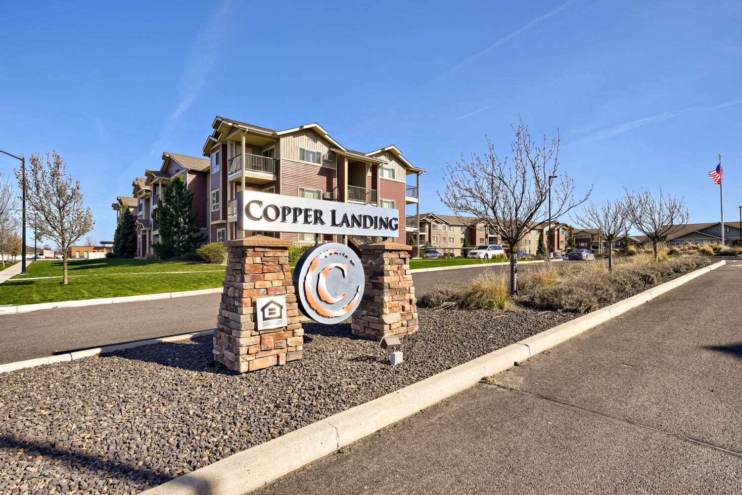 Entrance monument sign for Copper Hill Apartments surrounded by landscaped grounds in Spokane, Washington