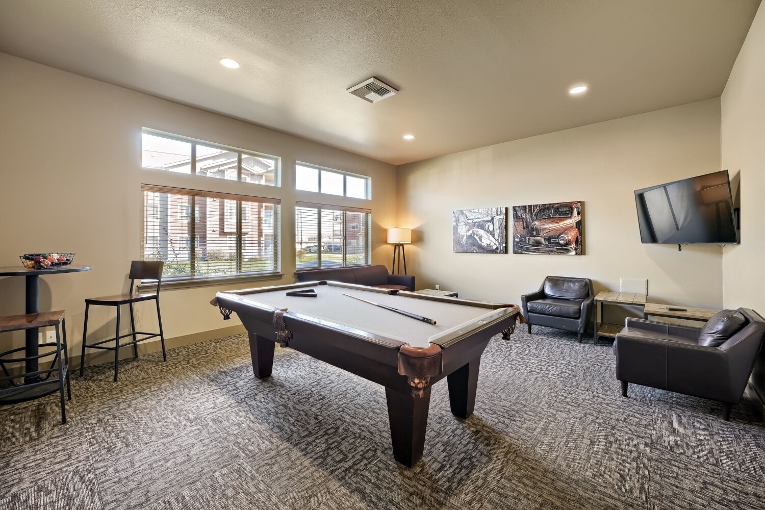 Resident game room at Copper Hill Apartments featuring a pool table, lounge seating, and entertainment space
