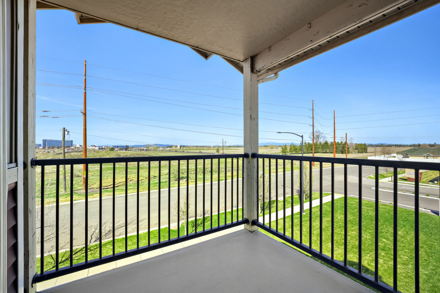 Private apartment balcony with scenic neighborhood and mountain views overlooking landscaped grounds