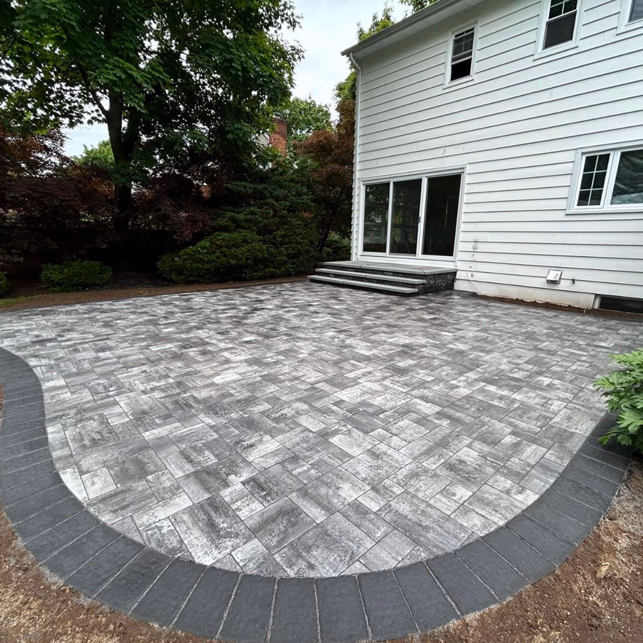 Segmental retaining wall installation by Roi Property Services designed for erosion control and long term stability in Metro Detroit