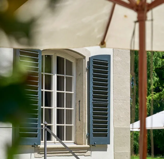 Hotelfassade mit grünen Fensterläden