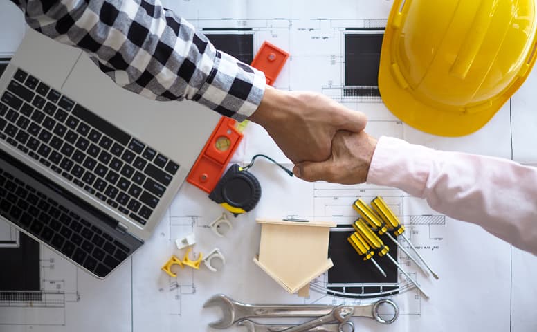 handshake top view over blueprint papers