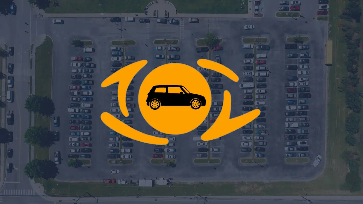 Aerial view of a large parking lot with an orange icon of a car surrounded by three curved arrows in the center.