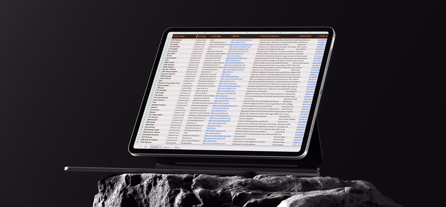 Laptop screen showing a detailed investor list spreadsheet with names, fund types, websites, and focus areas.