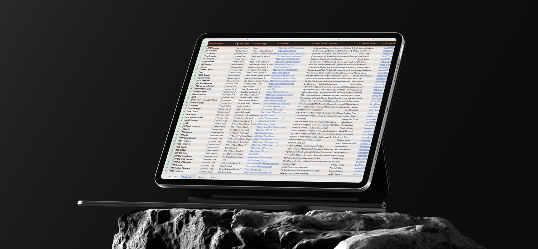 Laptop screen showing a detailed investor list spreadsheet with names, fund types, websites, and focus areas.