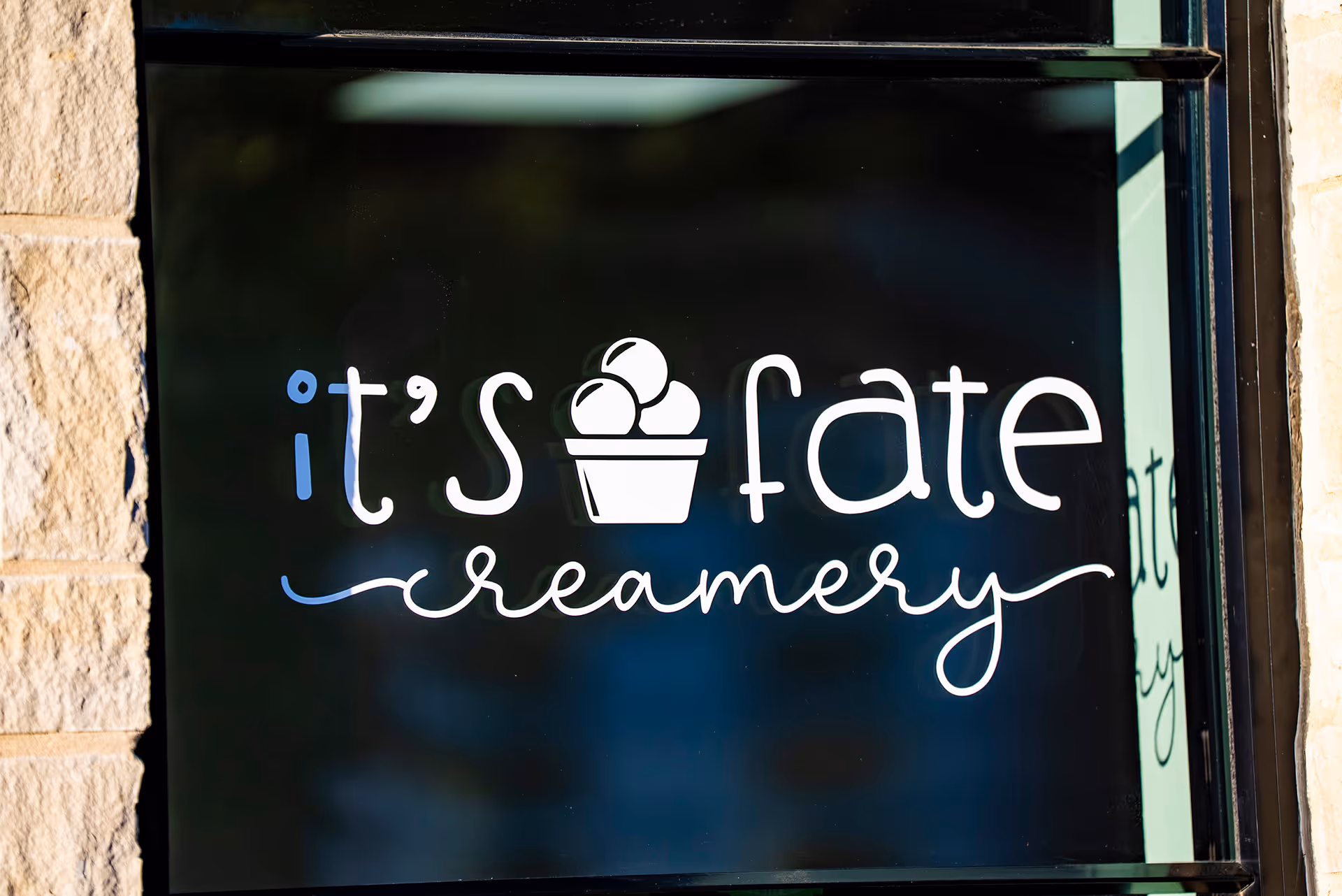 Window sign reading 'it's fate creamery' with an ice cream icon replacing the 'a' in fate.