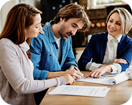 Three colleagues in a business meeting reviewing documents together.