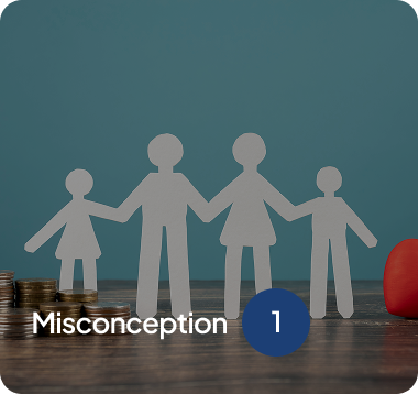 Paper cutout figures of a family holding hands on a wooden surface with coins stacked on the left and a red heart shape on the right, labeled 'Misconception 1'.