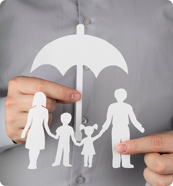 Person holding white paper cutouts of a family and an umbrella symbolizing protection or insurance.