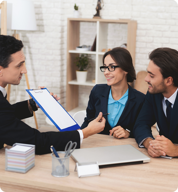 Man showing a clipboard to a smiling couple, likely during a business or consultation meeting in a modern office.