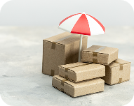 Stack of cardboard boxes with a red and white umbrella protecting the top box.