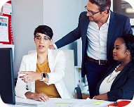 Three business professionals engaged in a discussion during a meeting.