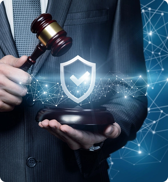 Person in suit holding a judge's gavel above a sound block with a digital shield and checkmark symbol floating above it, representing legal protection.