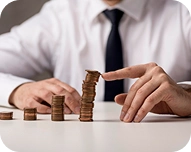 Person stacking coins in ascending order on a white table, symbolizing financial growth.
