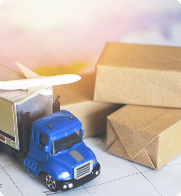 Toy blue cargo truck and white airplane model near small cardboard boxes on a map.