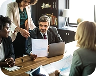 Business meeting with diverse professionals reviewing documents around a table in an office.