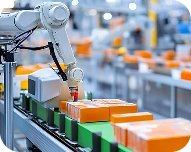 Robotic arm placing sealed orange and green boxes on a conveyor belt in a manufacturing facility.
