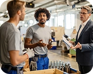 Man in business suit discussing with two factory workers in an industrial workspace with bottles on a conveyor.