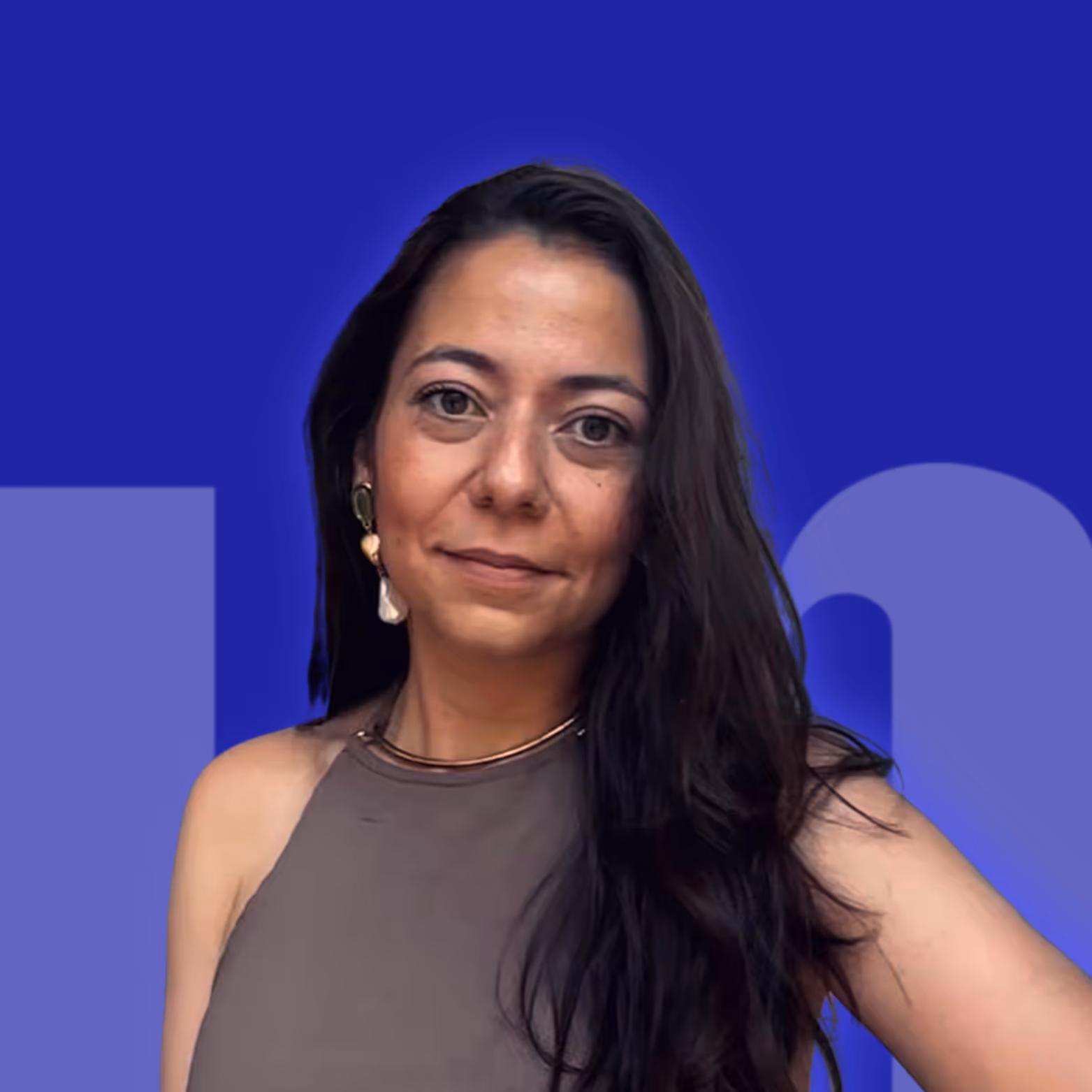 Portrait d'une femme aux cheveux longs et foncés, portant un haut marron sans manches et des boucles d'oreilles pendantes, sur fond bleu avec motifs géométriques.