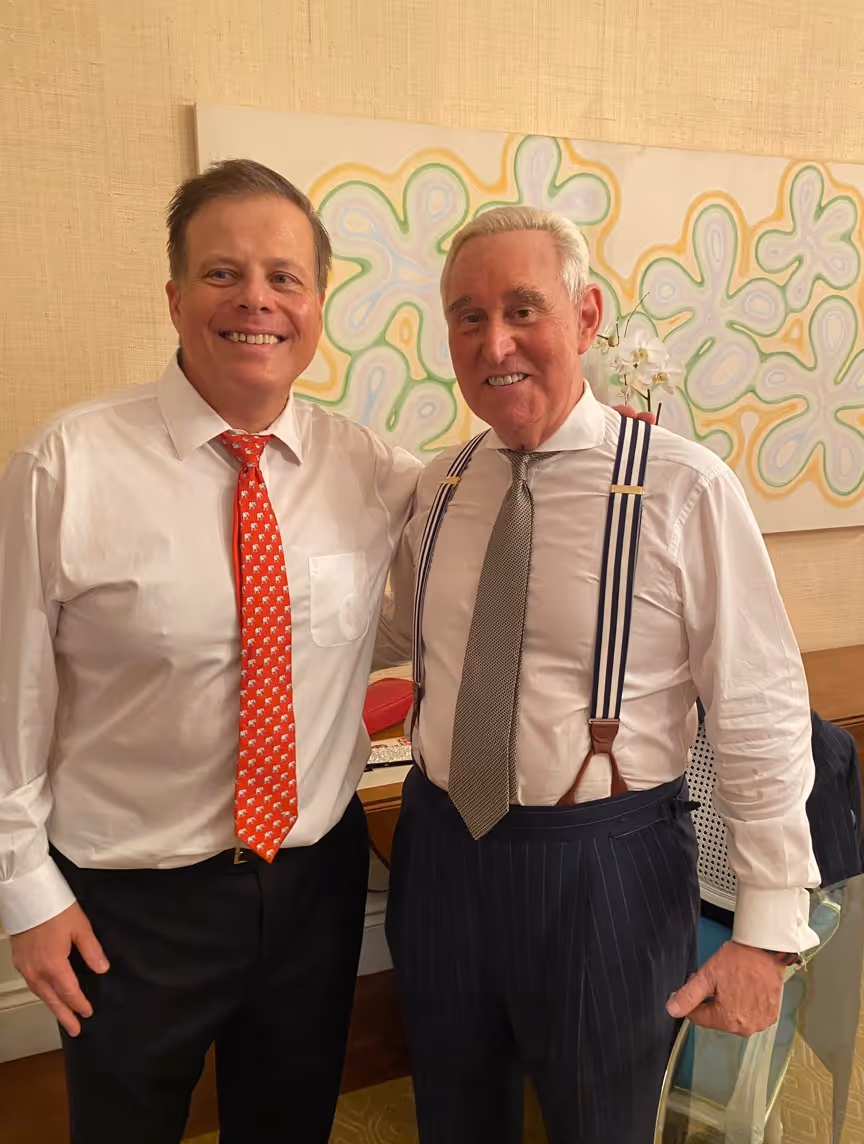Two men smiling and posing indoors.