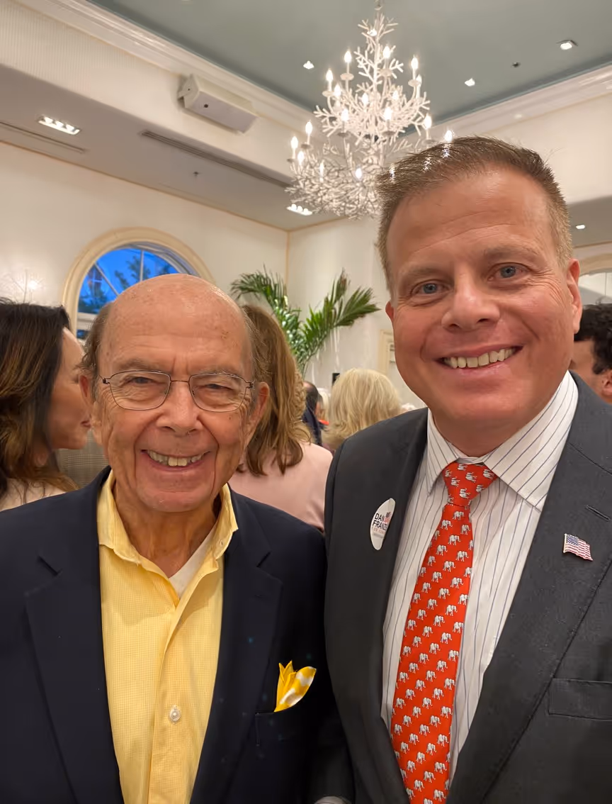 Two men smiling at an indoor event.
