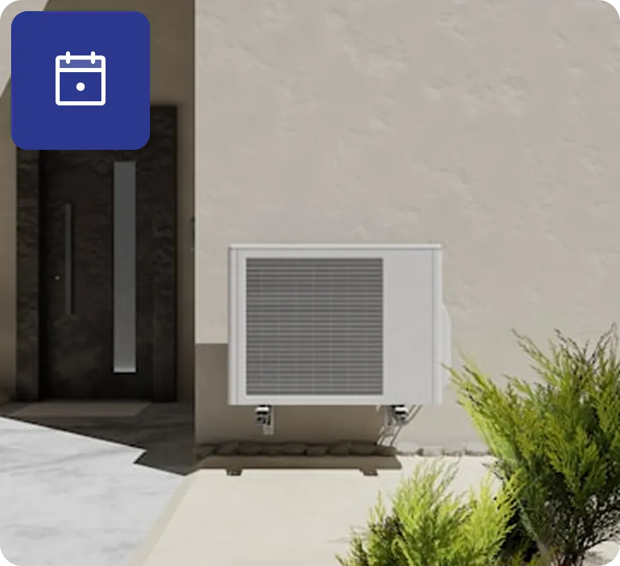 Outdoor air conditioning unit mounted on a wall next to a dark entrance door with greenery in the foreground.