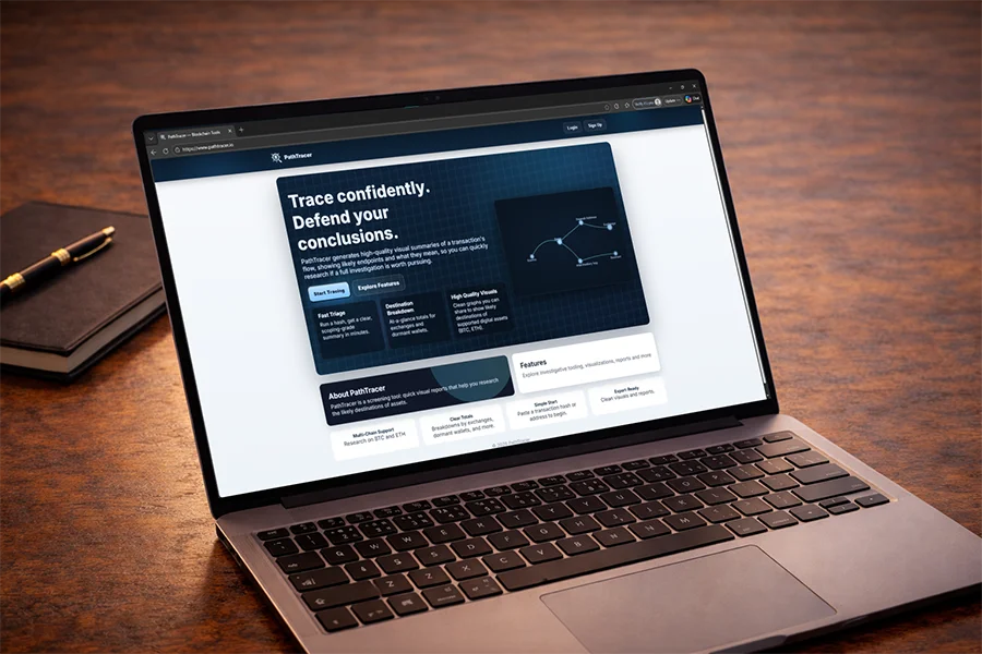 Laptop on wooden desk displaying a transaction analysis tool called PathTracer on screen.
