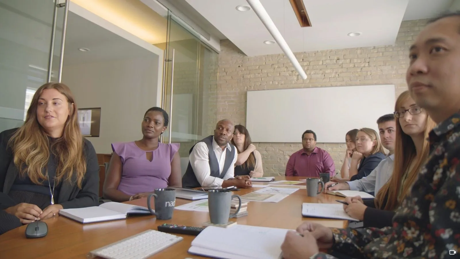 A group of people sitting around a table in a conference room.