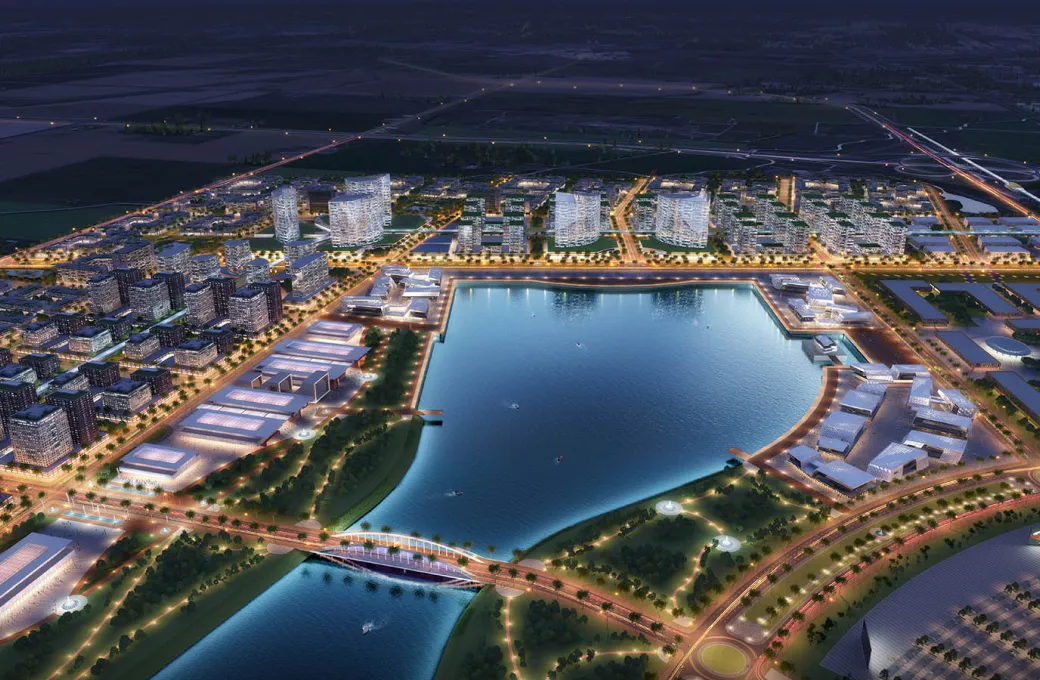 A city at night with a large body of water.