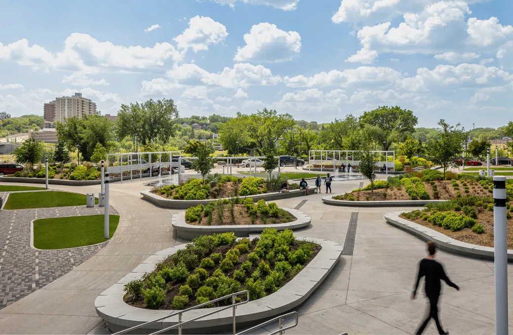 A man walking in a park with a bench in the background.
