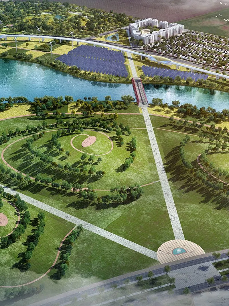 An aerial view of a modern sustainable urban park featuring green spaces, walking paths, a river, and solar panel fields with a pedestrian bridge.
