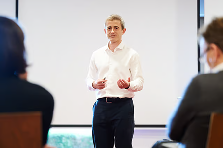 Scott Walker giving a presentation to an audience in a conference room.